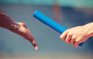 Two hands passing a baton.