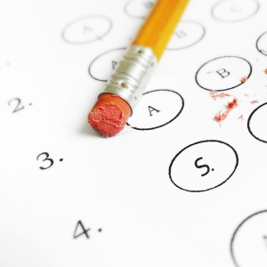ABIM Exam Questions: The eraser top of a pencil on top of a scantron sheet with eraser dust to indicate that answers may be changed on the ABIM exam.